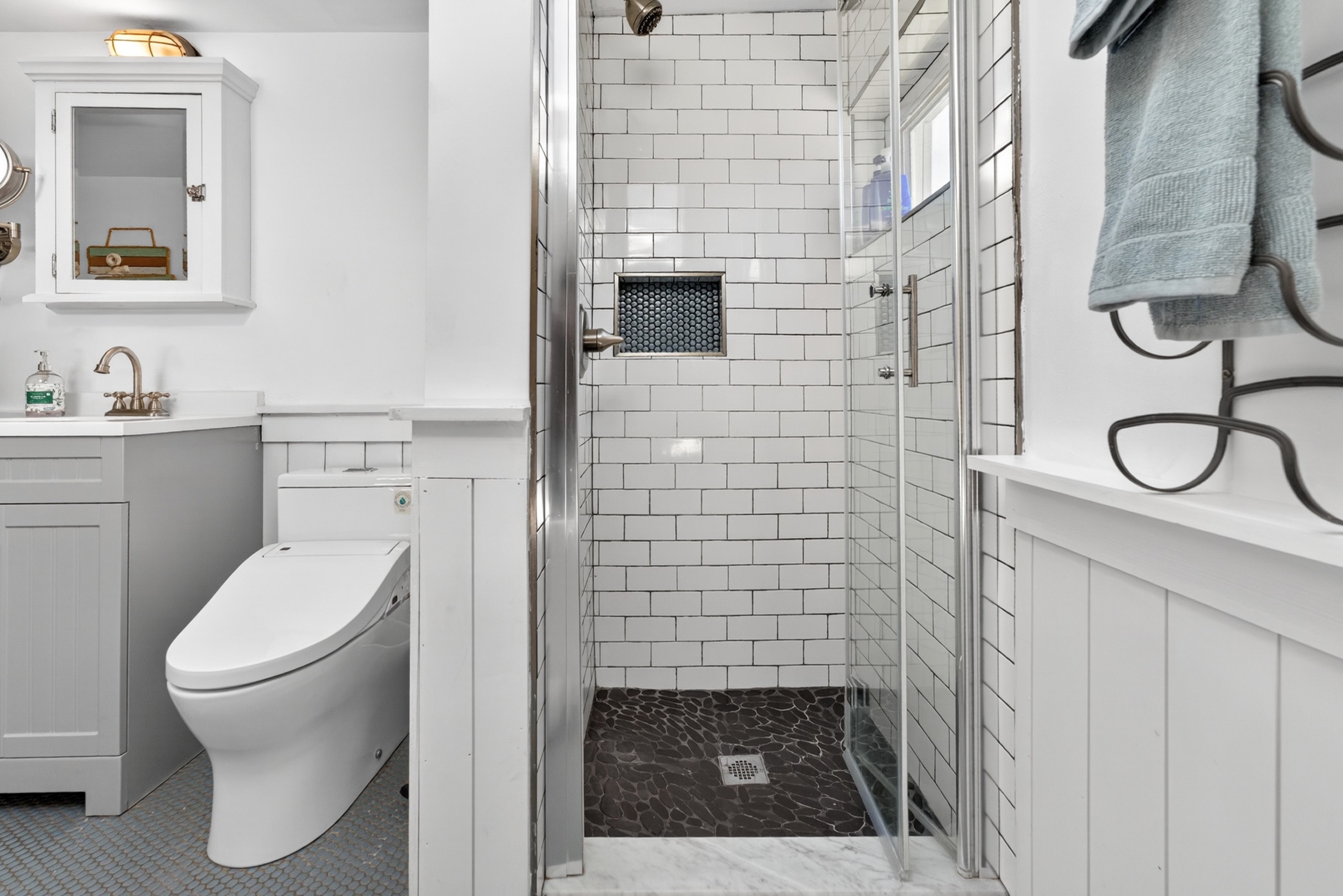 Upstairs full bath features classic penny tile flooring, a walk-in shower, and a large soaking tub perfect for relaxing after a day at the beach.
