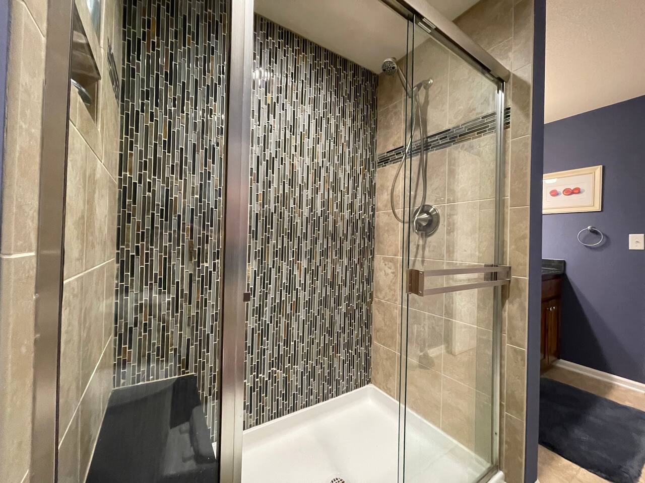 Bench seat in large walk in shower with removable handle shower head.