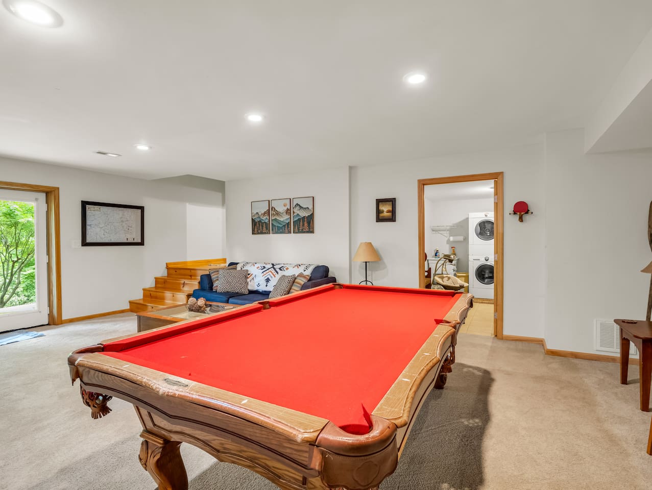 Basement with pool table, comfortable seating, plenty of board games, television, dart board, and exterior view of laundry area