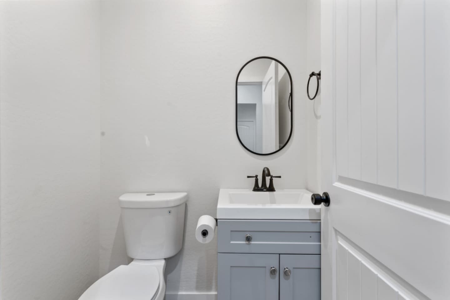 Convenient bathroom with vanity storage, mirror, and clean essentials for guest use.