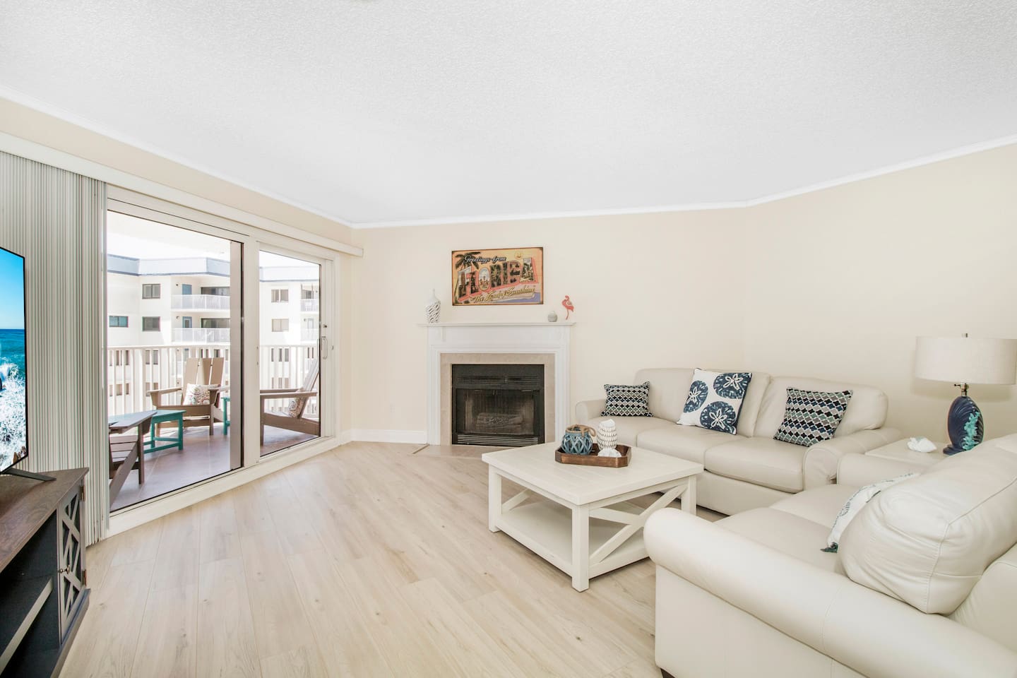 Living room with fireplace, open to the dining and kitchen area with pool and gulf views. 