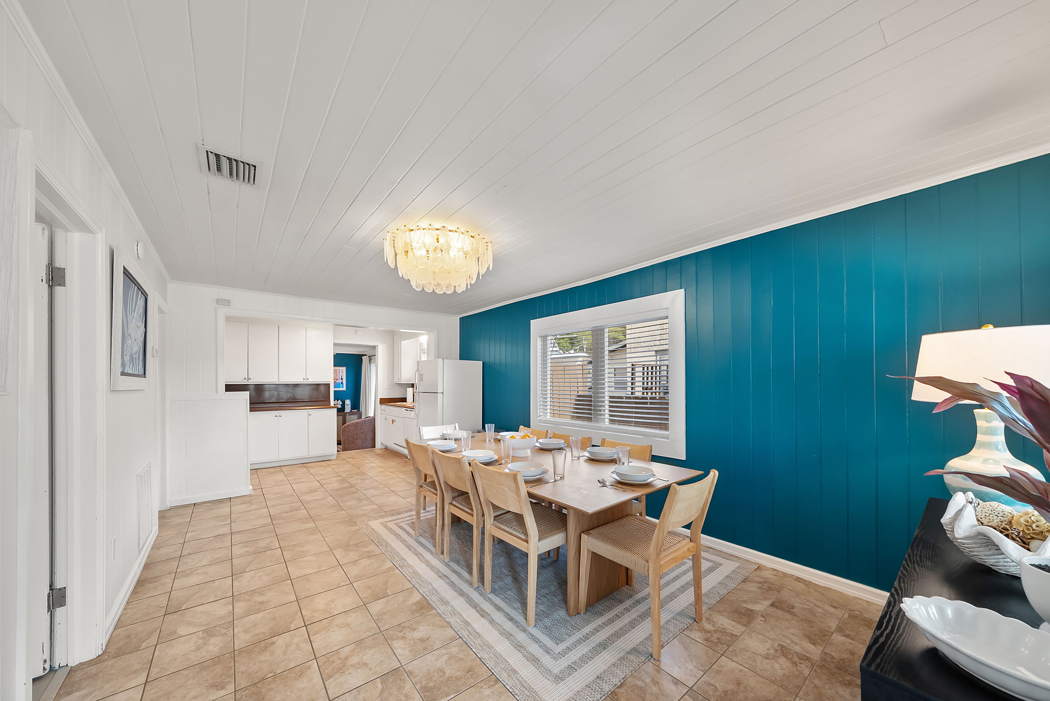 The dining room table seats 8 under a teal shiplap accent wall and
chandelier. A warm, well-lit space that earns its keep on seafood nights.