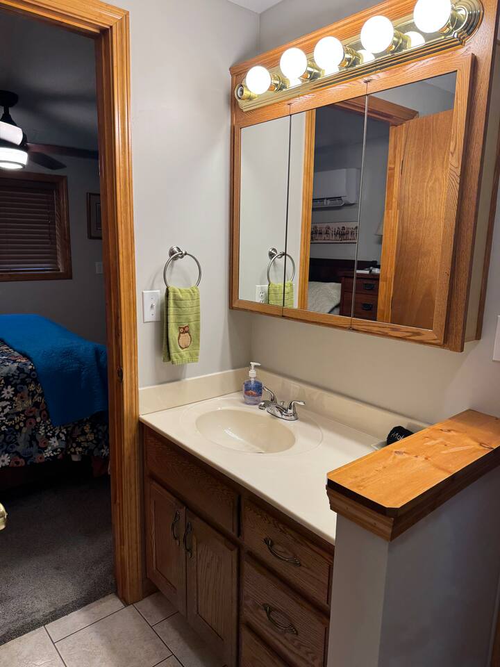Bathroom has toilet, sink with lots of lighting, shower, and washer and dryer. Outdoor shower available in summer.