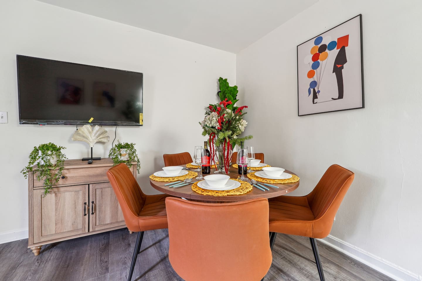 Enjoy a warm and inviting dining area combined with the living room, featuring a dining table set where you can enjoy meals while watching TV. The space also includes a ceiling fan for extra comfort and a cozy atmosphere for gathering and relaxing.
