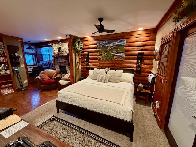 The Pinecrest Room - a spacious primary suite with a king‑size bed, lodge‑style décor, and a cozy electric fireplace glow.