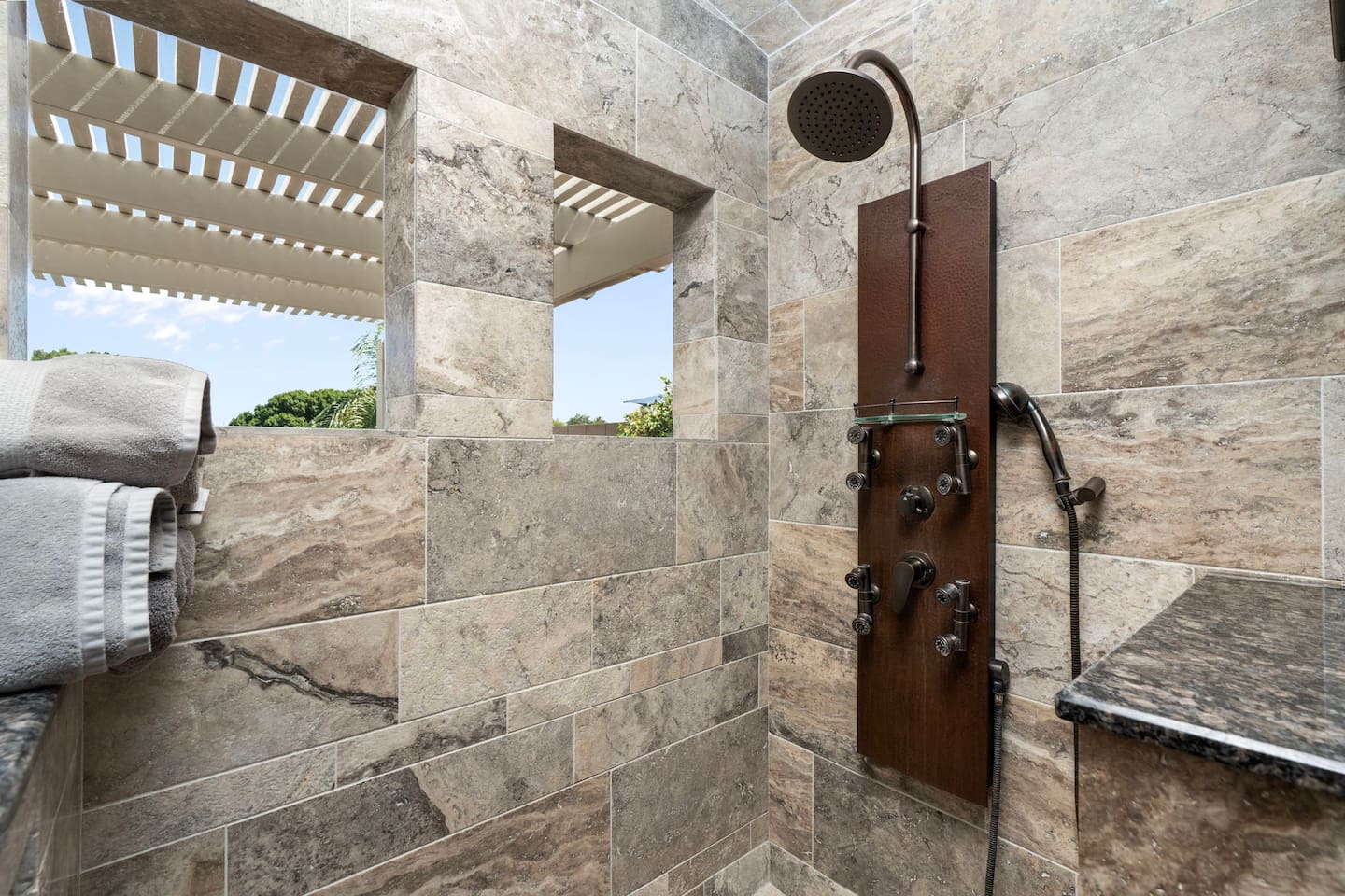 The oversized walk-in shower opens to the sky through a pergola window cutout — a rare and luxurious touch that makes every morning feel like a resort experience.