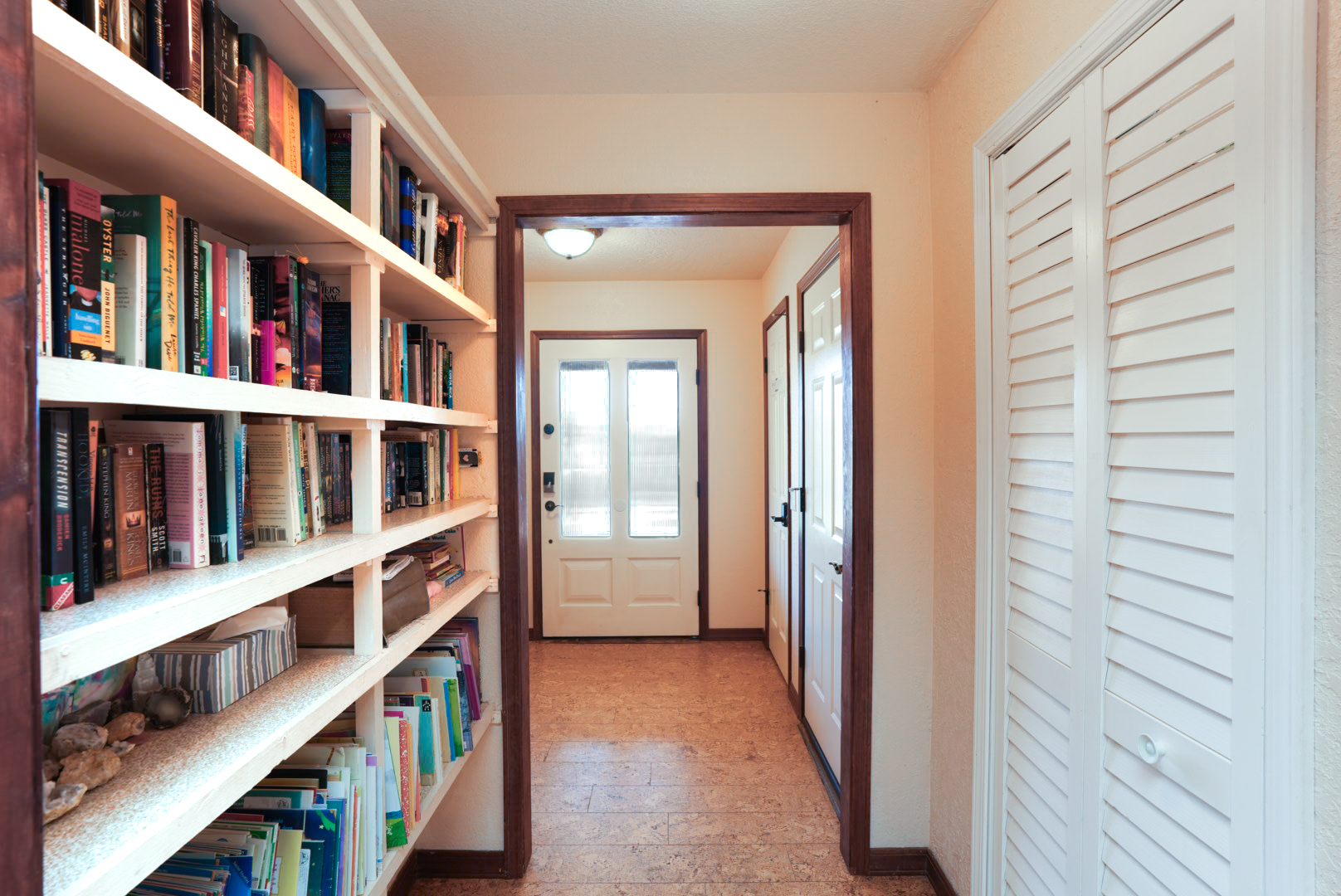 Welcoming entry hallway featuring a library wall—browse books, unwind, and feel right at home the moment you arrive.