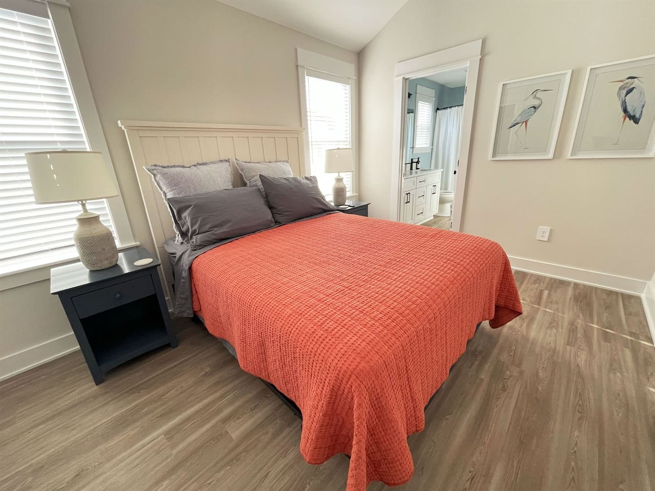 Cozy third bedroom featuring a comfortable queen bed and soft natural light.