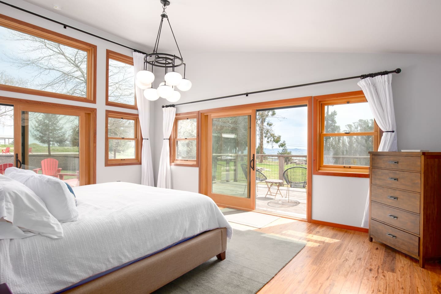 Enjoy the utmost in relaxation in our primary bedroom, which features easy access to the backyard, mini split-type AC and a walk-in closet. Beside tables and warm lighting enhance the mood. There is a full size dresser for storage of personal items. 