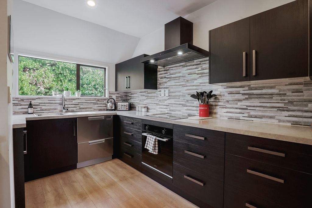 The kitchen flows through to the dining area, keeping cooking, meals and conversation connected during the Fernhill Mountain Escape stay.
