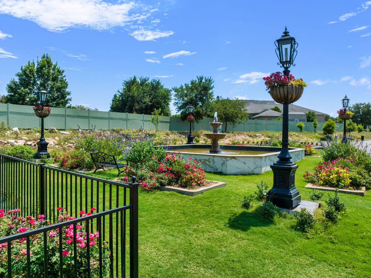 Vintage lampposts and vibrant flower beds line the garden path, creating a picturesque spot for an evening walk.