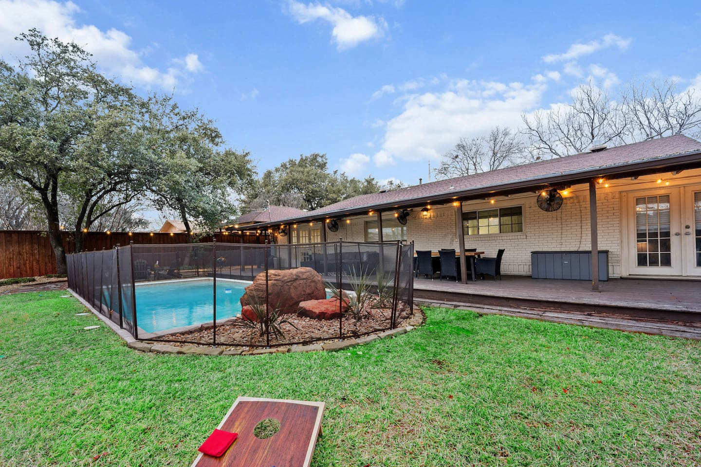 Spacious covered deck, fenced pool, and plenty of green space for games and gatherings.
