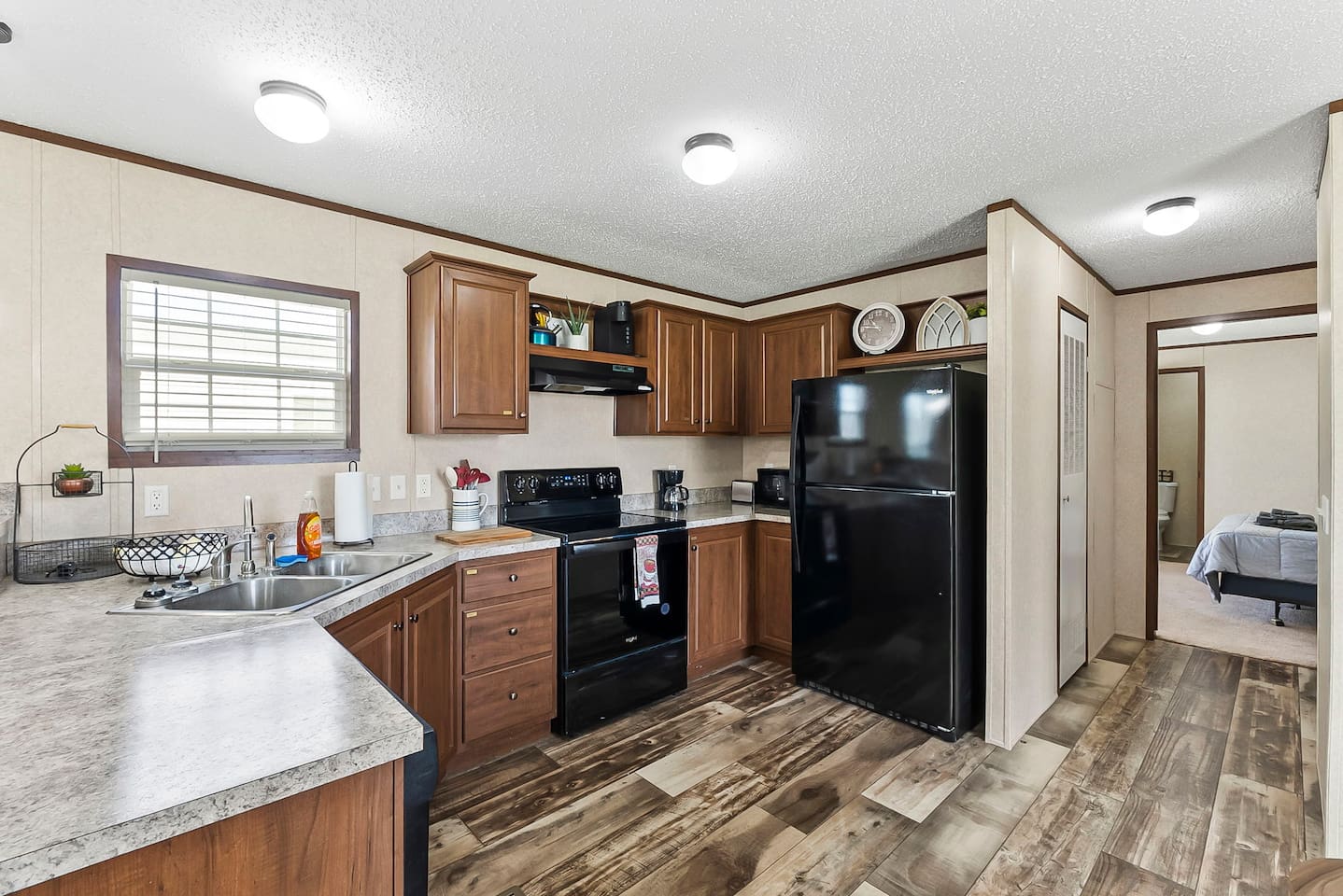 Spacious kitchen with wraparound counters, black appliances, and direct access to nearby bedrooms for added convenience.