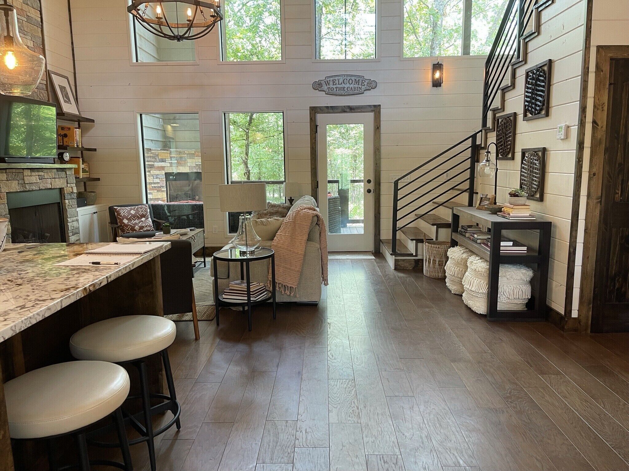 Entry way view of the cabin. Dining area is on the right, the fully-equipped kitchen on the left. Large wall of windows on the back overlooking the Ouachita National Forest.