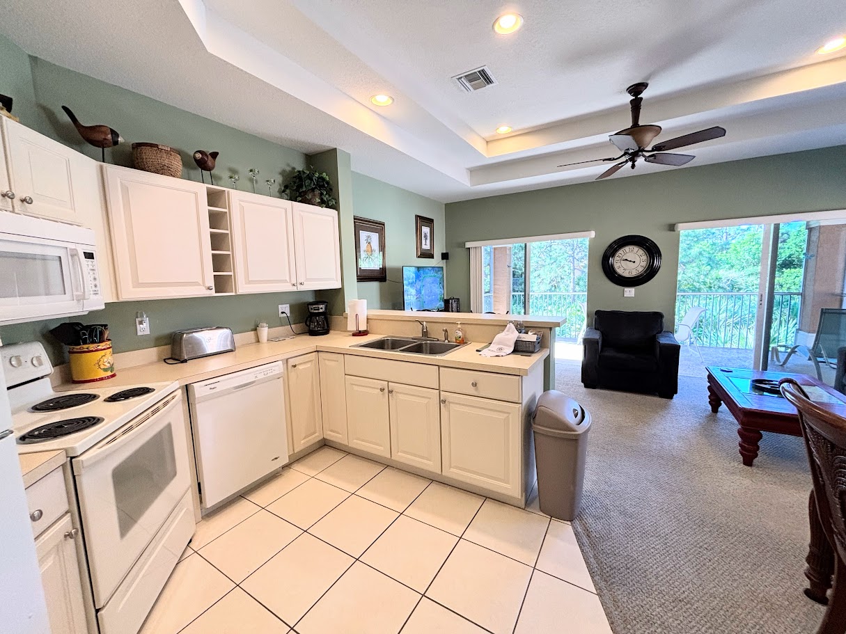 Bright open kitchen and living space with high ceilings, full-size appliances, and easy access to the main living area.