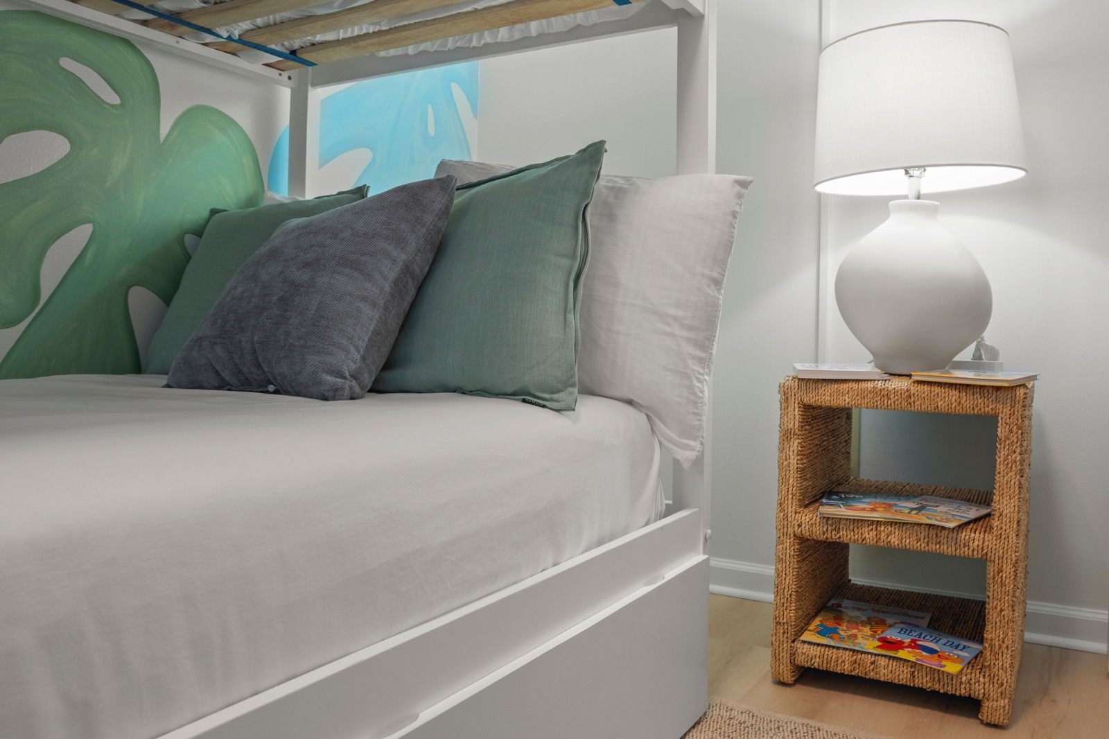 Sink into soft pillows and drift off beneath calming tropical tones, where cozy textures and gentle lighting end a beach-filled day perfectly.