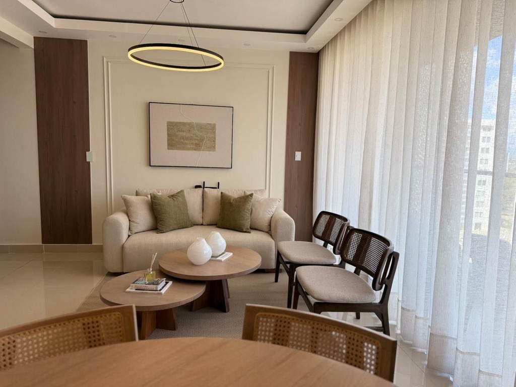 Bright and inviting living space with comfortable seating and floor-to-ceiling balcony windows—perfect for relaxing and enjoying the view. ✨
