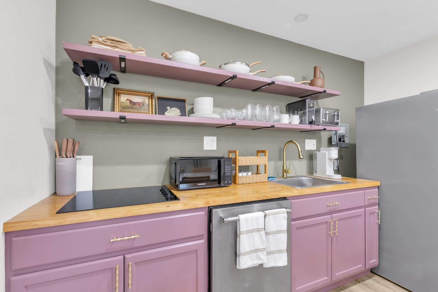Cook and sip in comfort and style—this curated kitchen includes a 4-burner stove, oven, microwave, Keurig coffee maker, and complete cookware set.