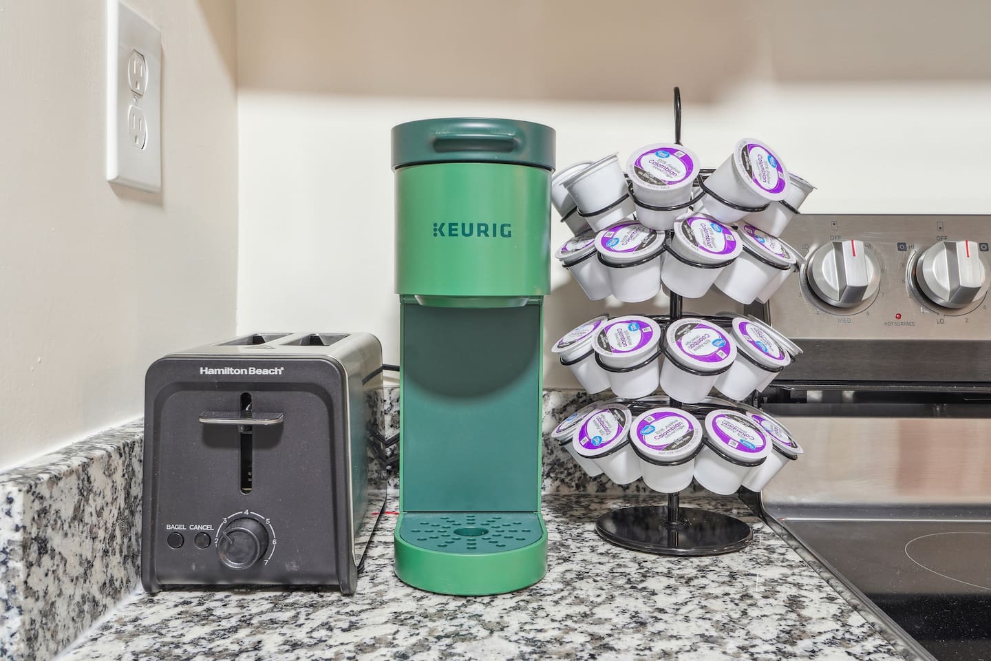 A fully equipped kitchen with a refrigerator, microwave, stove, oven, dishwasher, coffee maker, kettle, toaster, and blender. Includes plates, bowls, utensils, pots, and pans, plus four bar chairs for casual dining or socializing.
