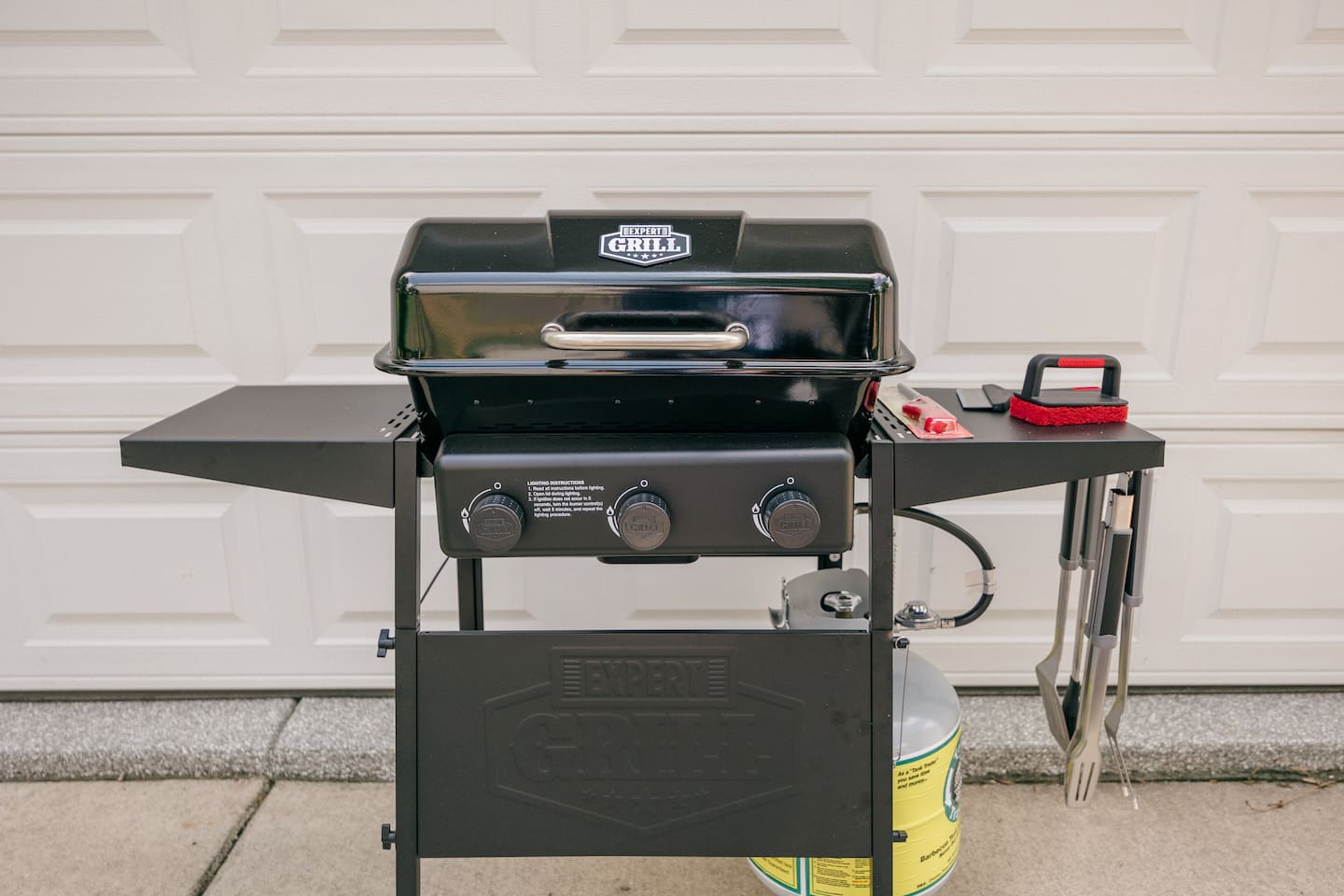 New propane grill with tools and grill cleaner. 