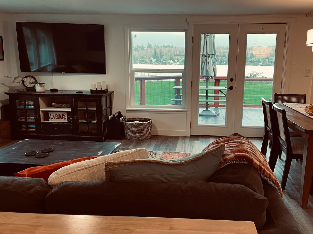 A cozy living space with a TV, where the view stretches across the lake, bringing calm and connection to the room.