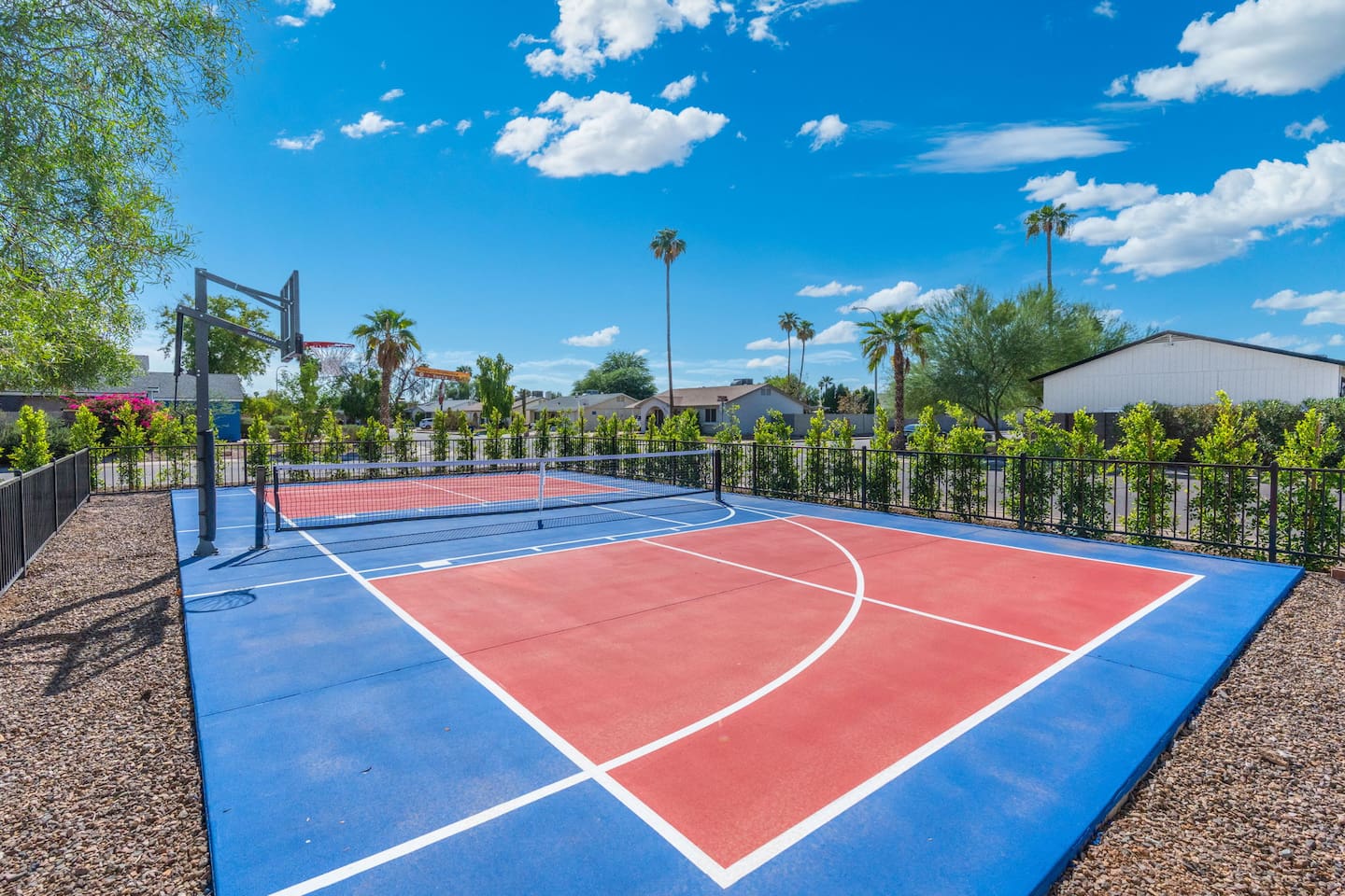 Community sports court with basketball and tennis facilities overlooking manicured grounds.