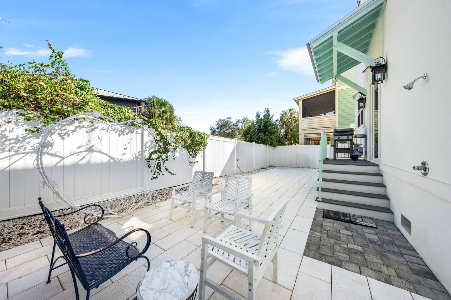 Spacious, fenced-in backyard! ✨ Snap the perfect bachelorette or family selfie on whimsical heart-shaped bench,  fire up the outdoor grill for a sunset BBQ on the sleek pavers. Convenient outdoor shower to take off sand.