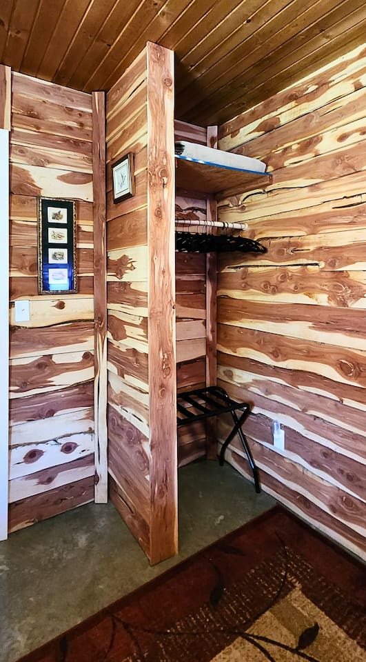 A charming cedar-lined nook with hangers, shelves, and a luggage rack—this rustic closet blends form and function, offering thoughtful storage that fits right into the lodge’s cozy, cabin-style aesthetic.