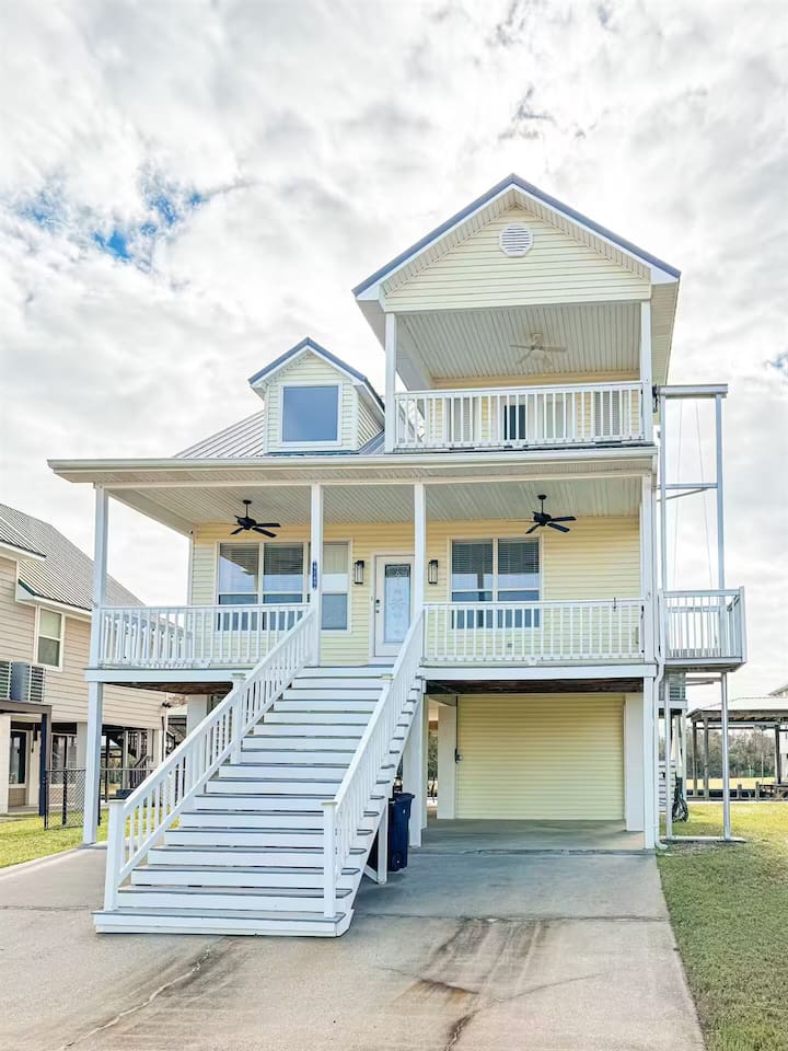 Charming elevated beach home with wraparound porches, covered parking, and breezy outdoor spaces
