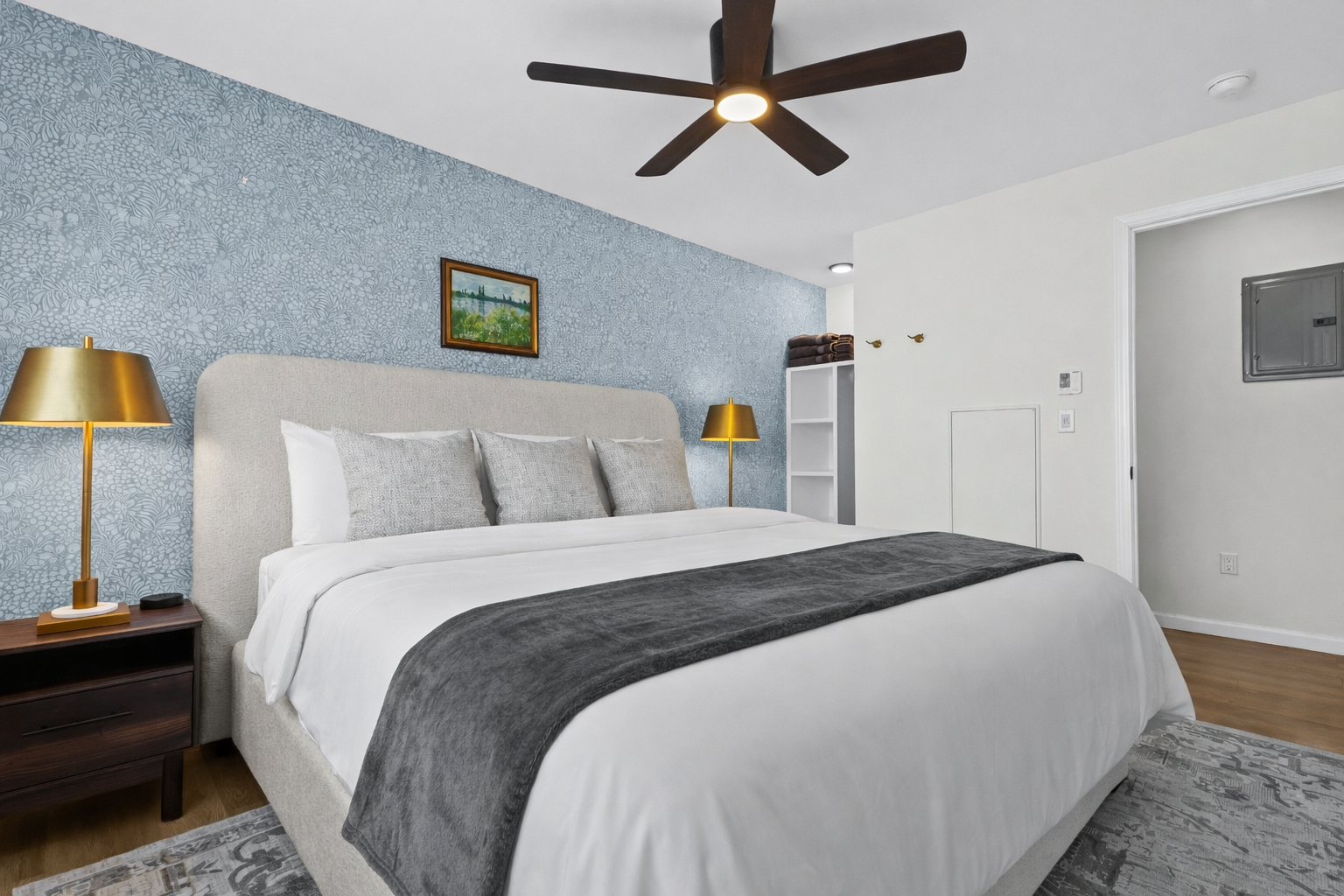 Spacious, calming bedroom with a plush bed, soft linens, ceiling fan, and warm lighting—designed for restful sleep and a peaceful stay.