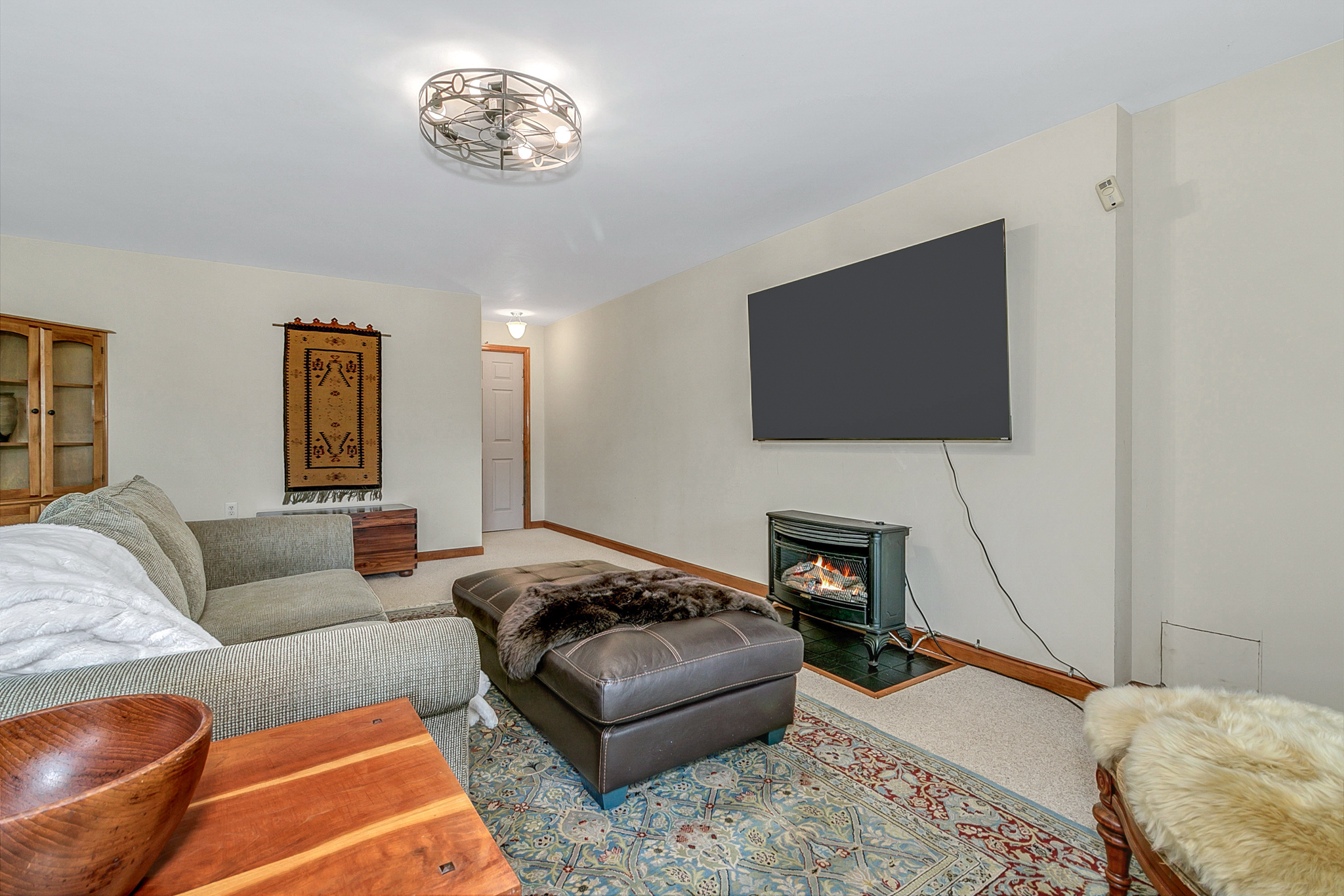 Basement Entertainment Room with Large Smart TV and Gas Fireplace