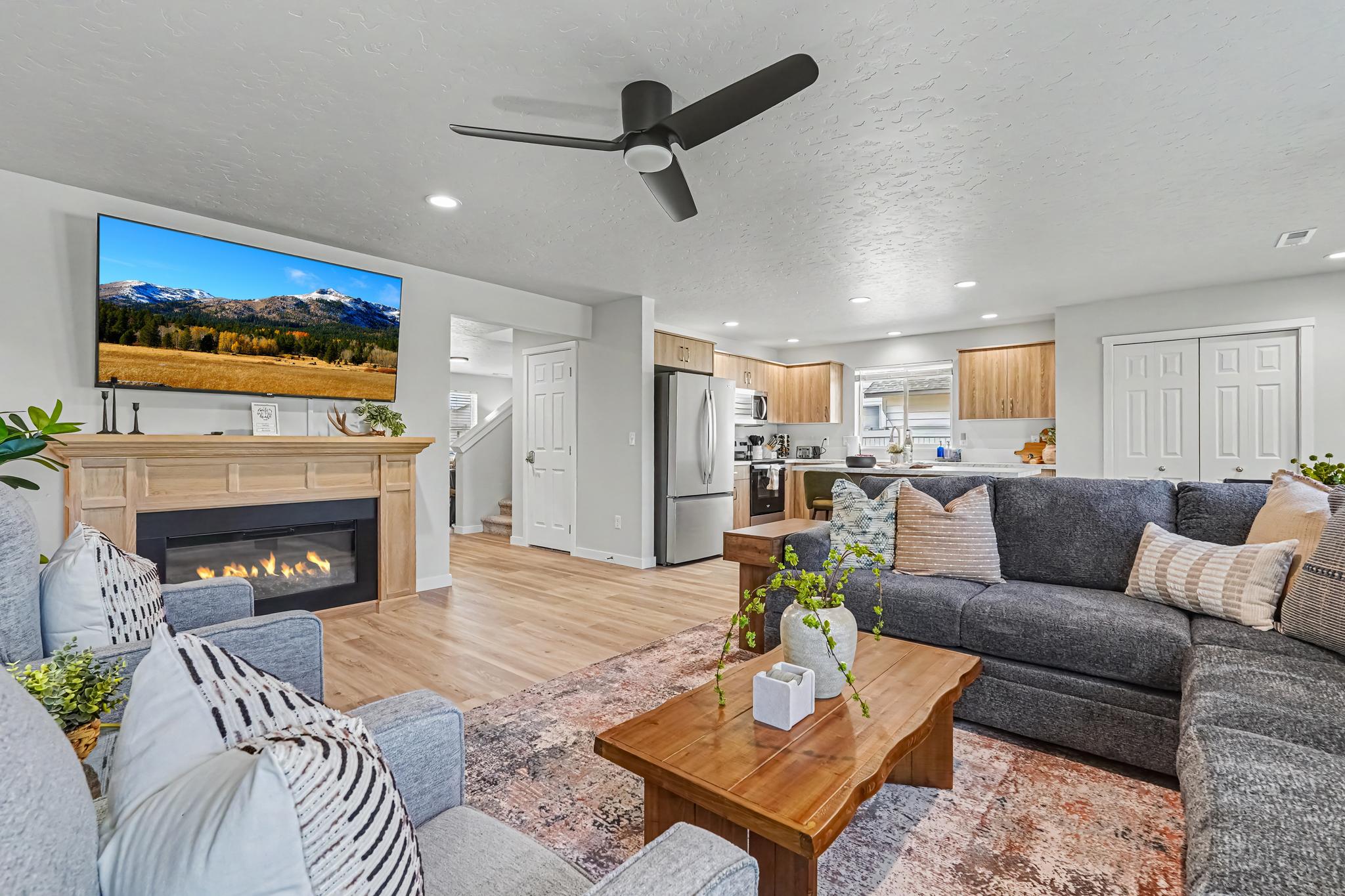 Relax in the back living room, featuring a 65" Smart TV and a cozy gas fireplace, perfect for unwinding after a long day. 