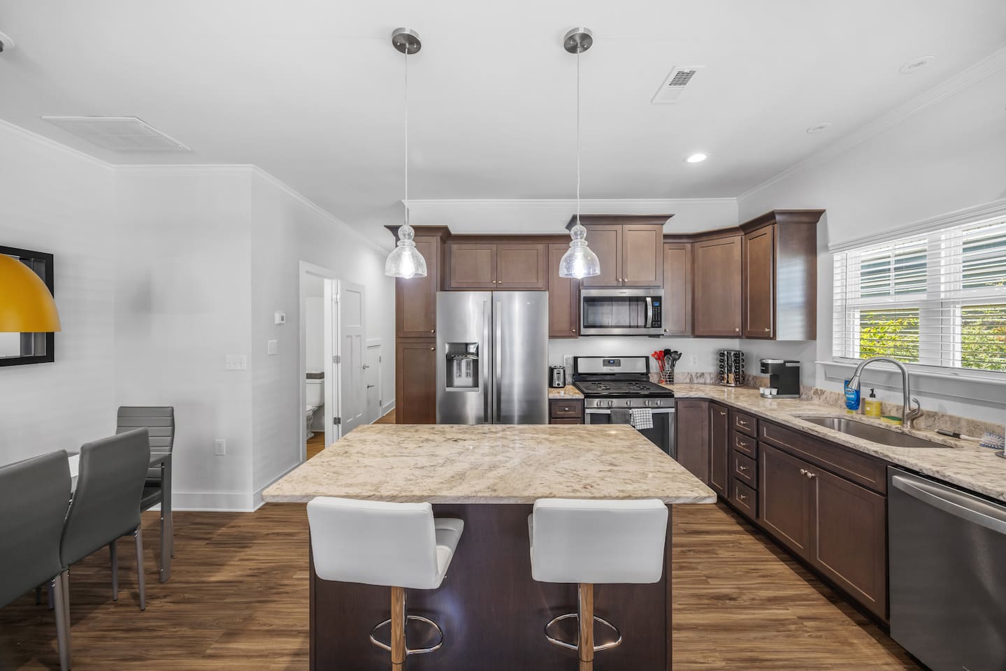 Enjoy cooking in a fully equipped kitchen featuring stainless steel appliances, granite countertops, and a spacious island.