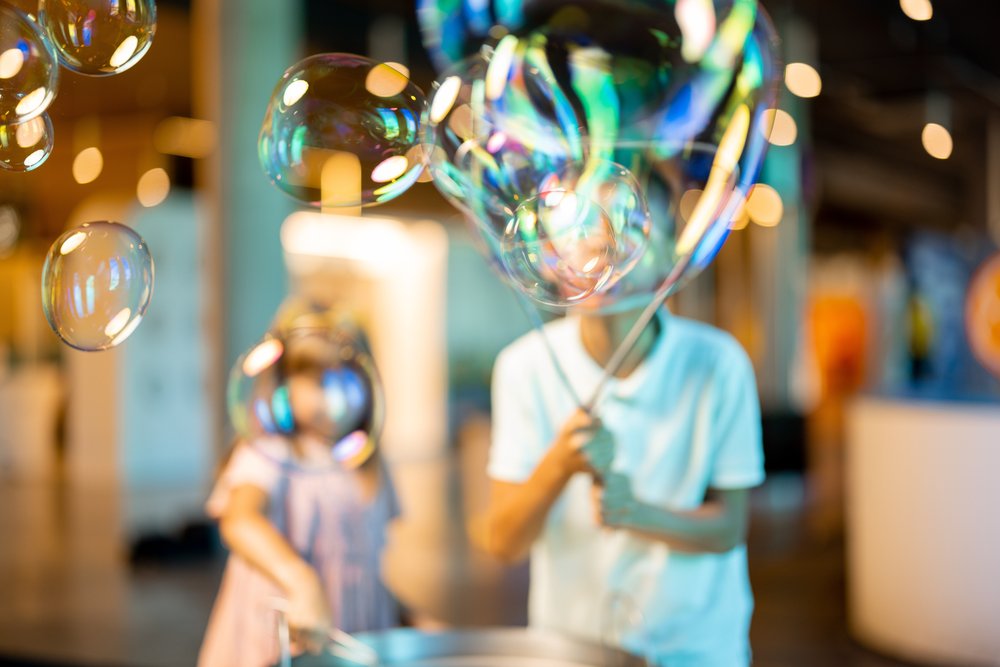 Children playing with soap bubbles in a museum