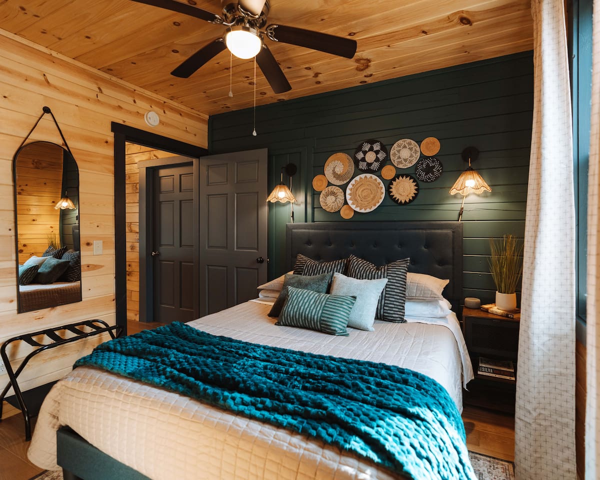 A thoughtfully curated bedroom featuring deep jewel tones