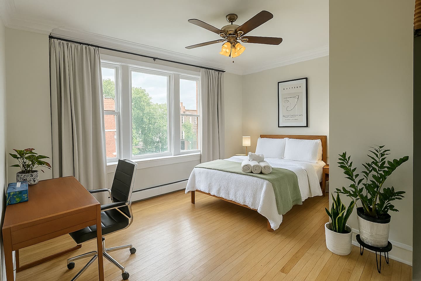 Bright, spacious bedroom with high-quality bedding, large windows for natural light, and a dedicated desk for comfortable remote work.