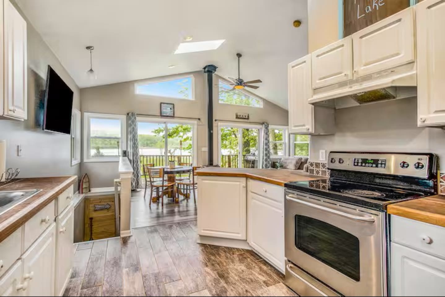 Beautiful view of the kitchen and living area. The upper deck is seen here overlooking the lake. On the deck is plenty of seating area and grilling space