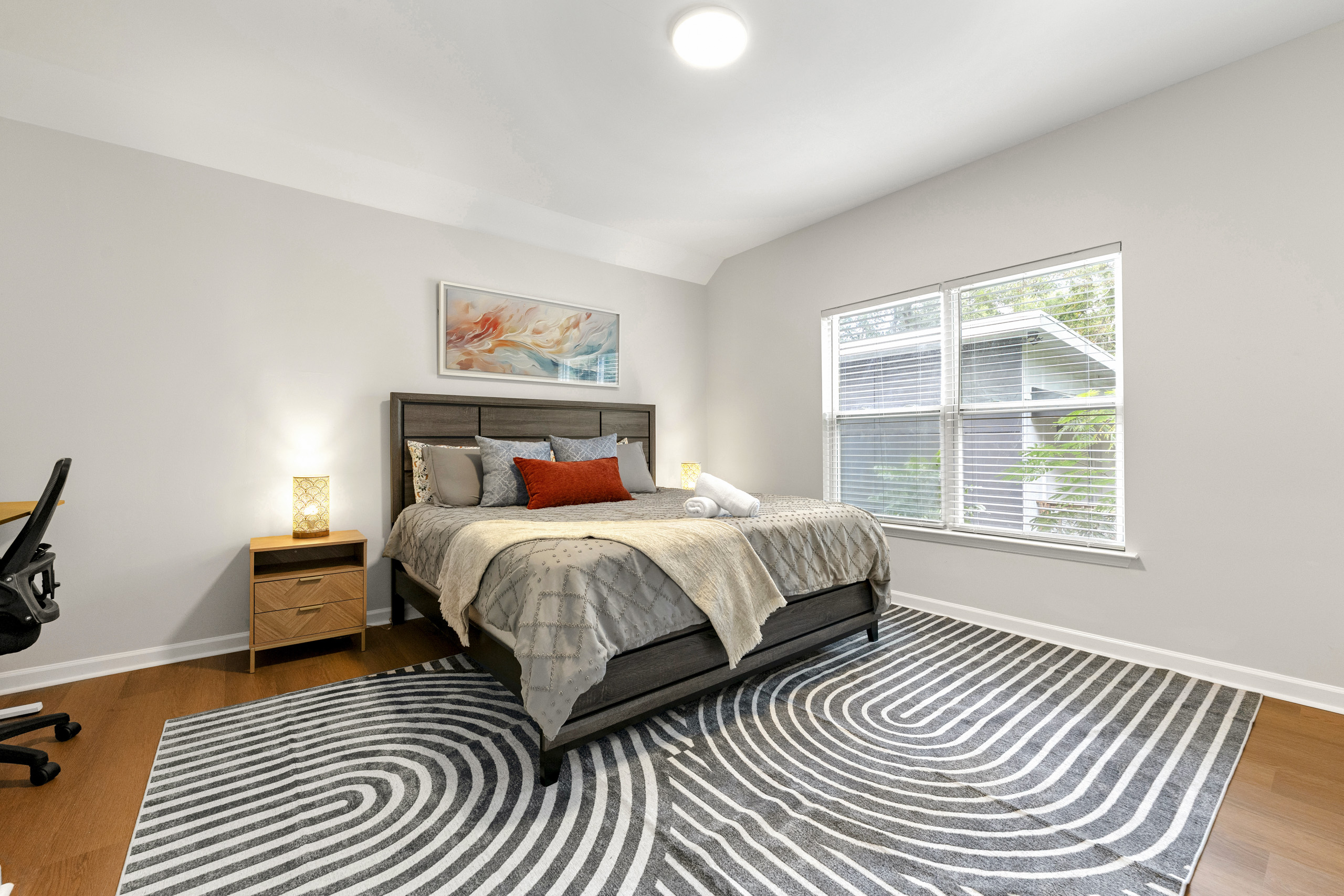 Unwind in this bright king bedroom with soothing colors and cozy textures.
