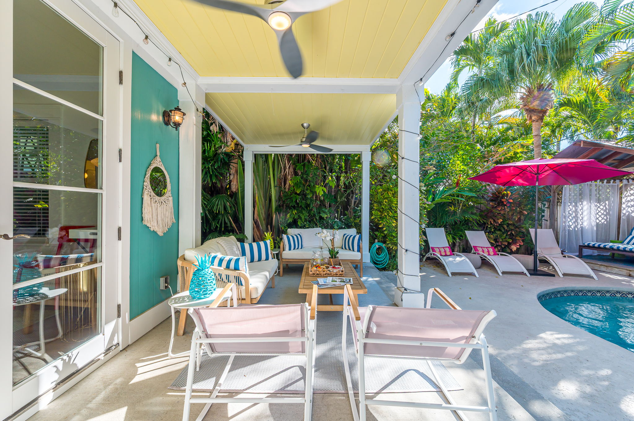 Step into your private tropical oasis featuring a heated pool, sun loungers, an outdoor shower, and a romantic string-lit cabana. Enjoy relaxing or entertaining under the covered patio with comfortable seating and dining, and magnificent pool views.
