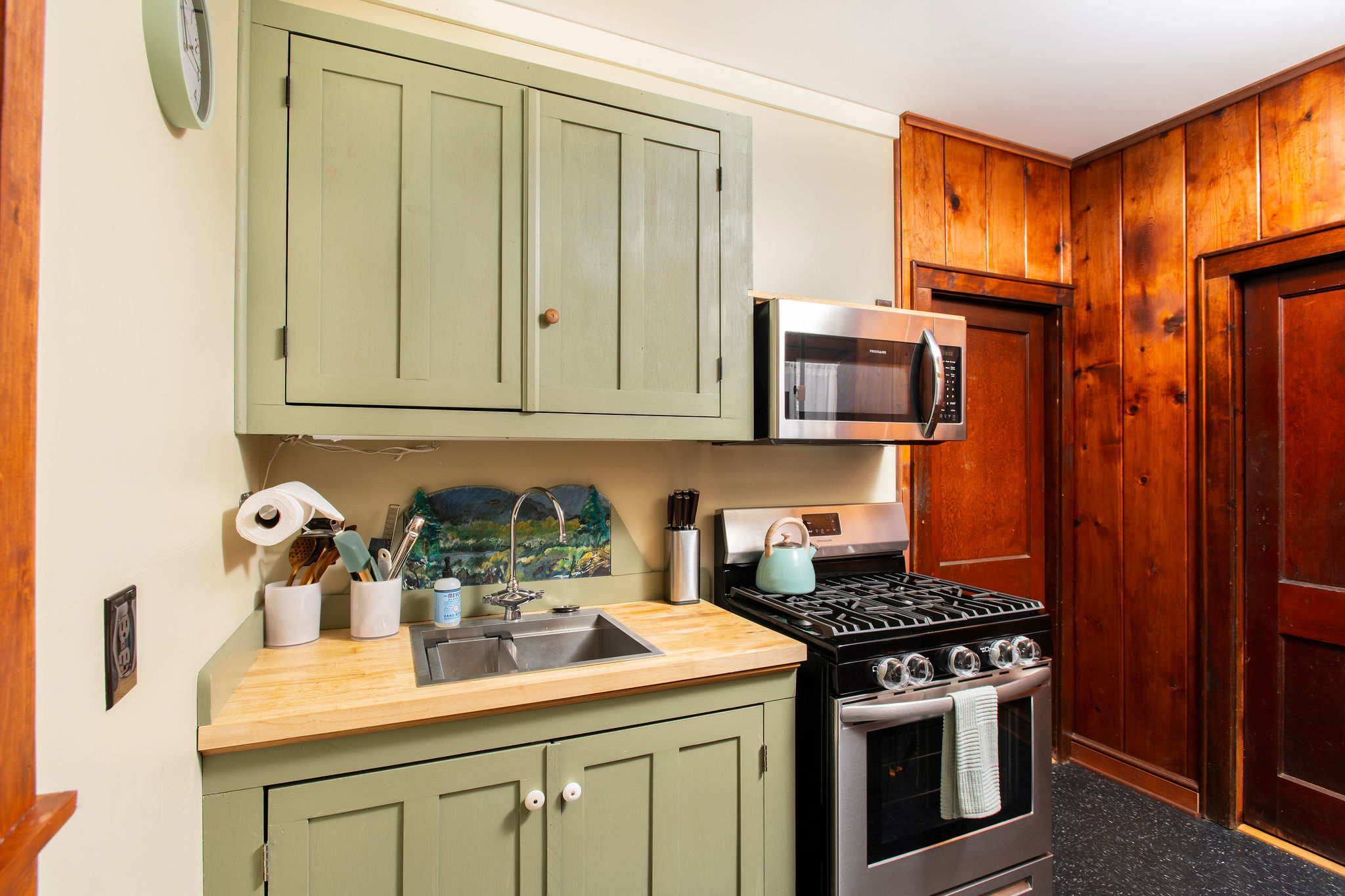 Well-appointed kitchen with stainless range, microwave and butcher-block counters