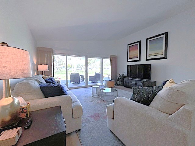Living room has great views, flat screen, and remote control shades.