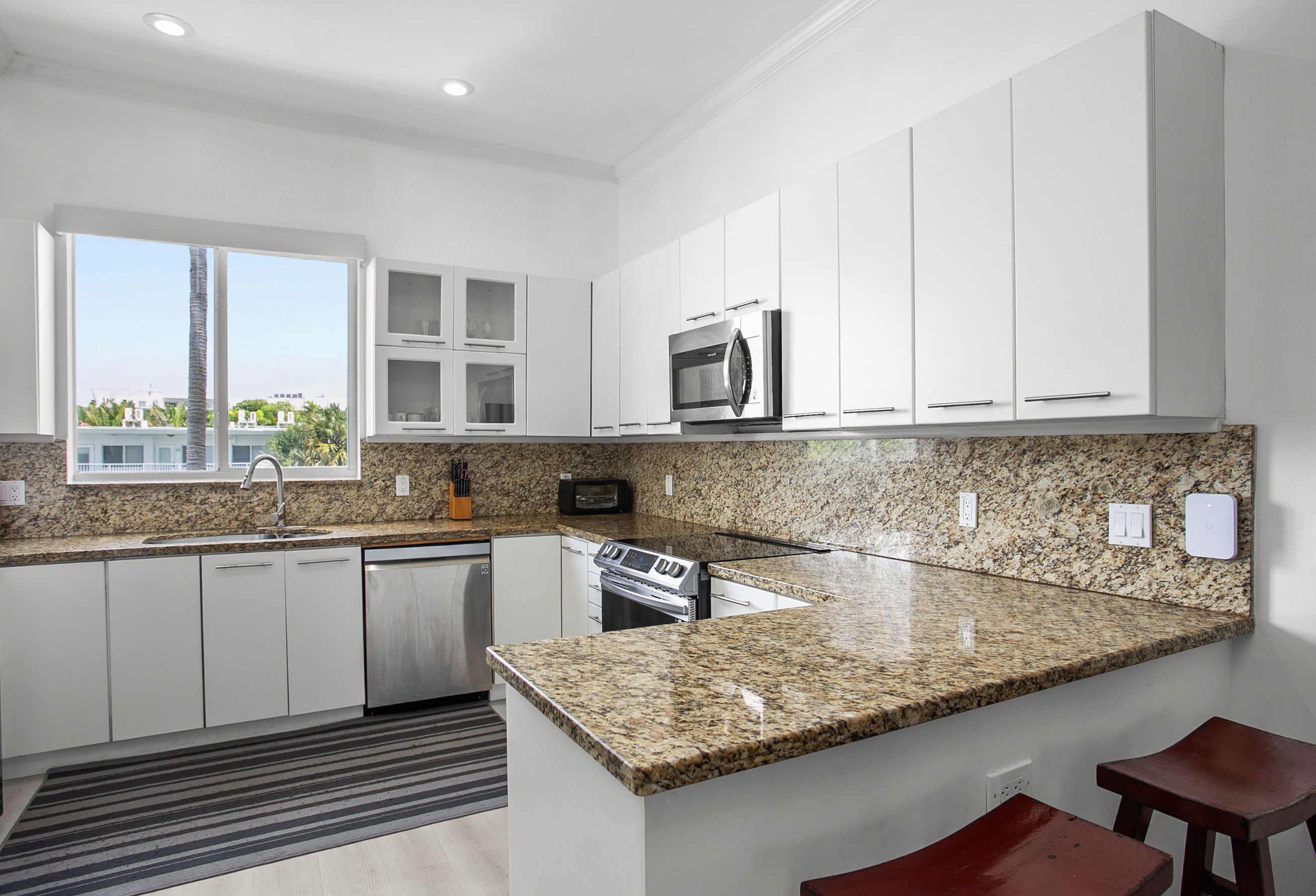 Chef's kitchen with dual-basin sink and breakfast counter. LG laundry tower right next to it.