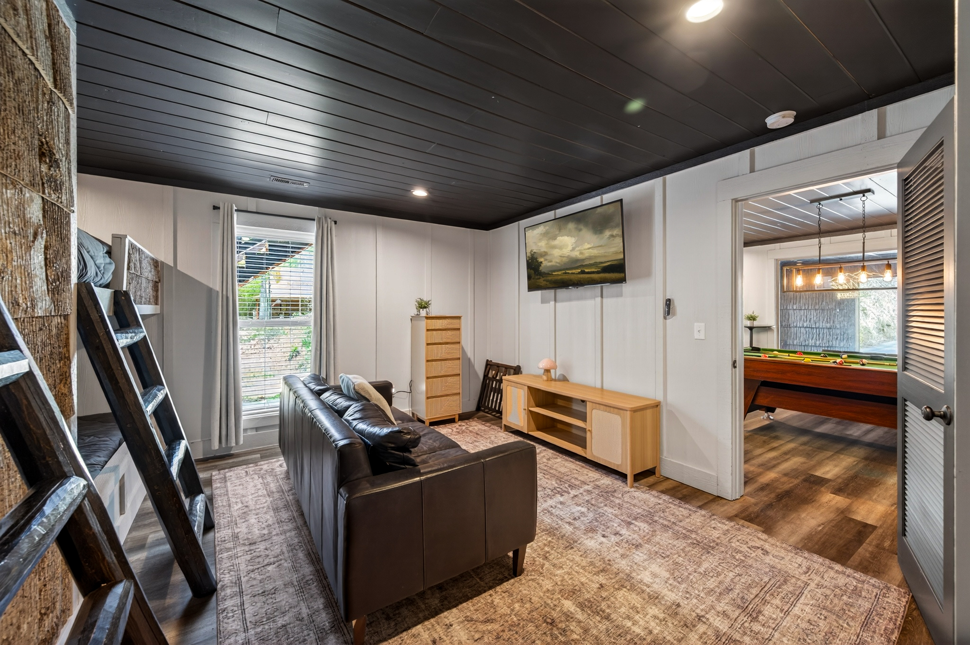 TV, sofa and storage in bunk room.