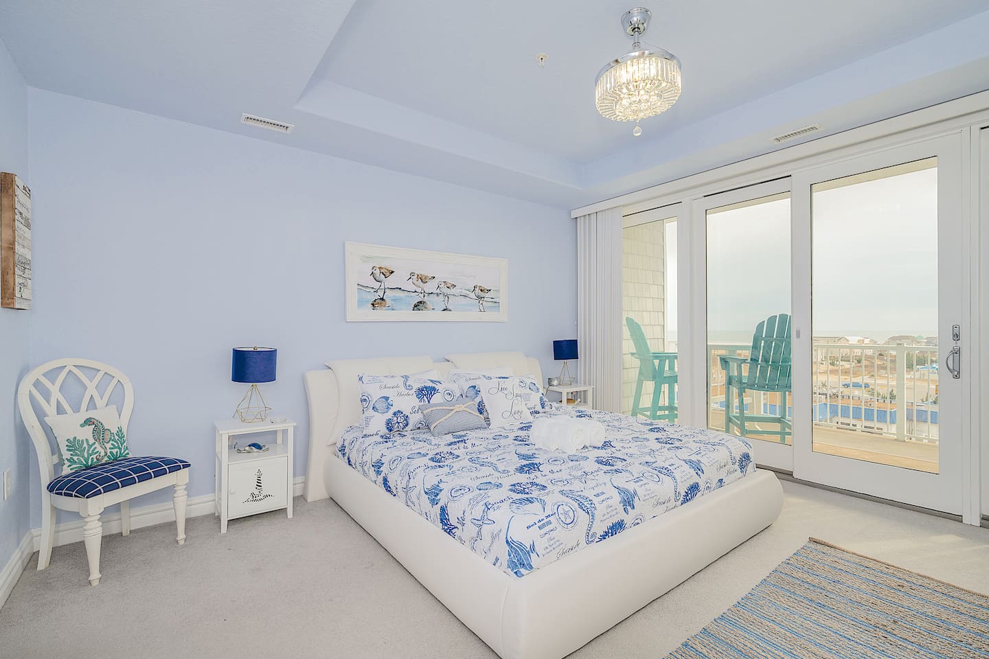 Wake up to breathtaking beach views in this cozy coastal king bedroom  Sliding doors open to your private balcony with Adirondack chairs perfect for morning coffee ☕️