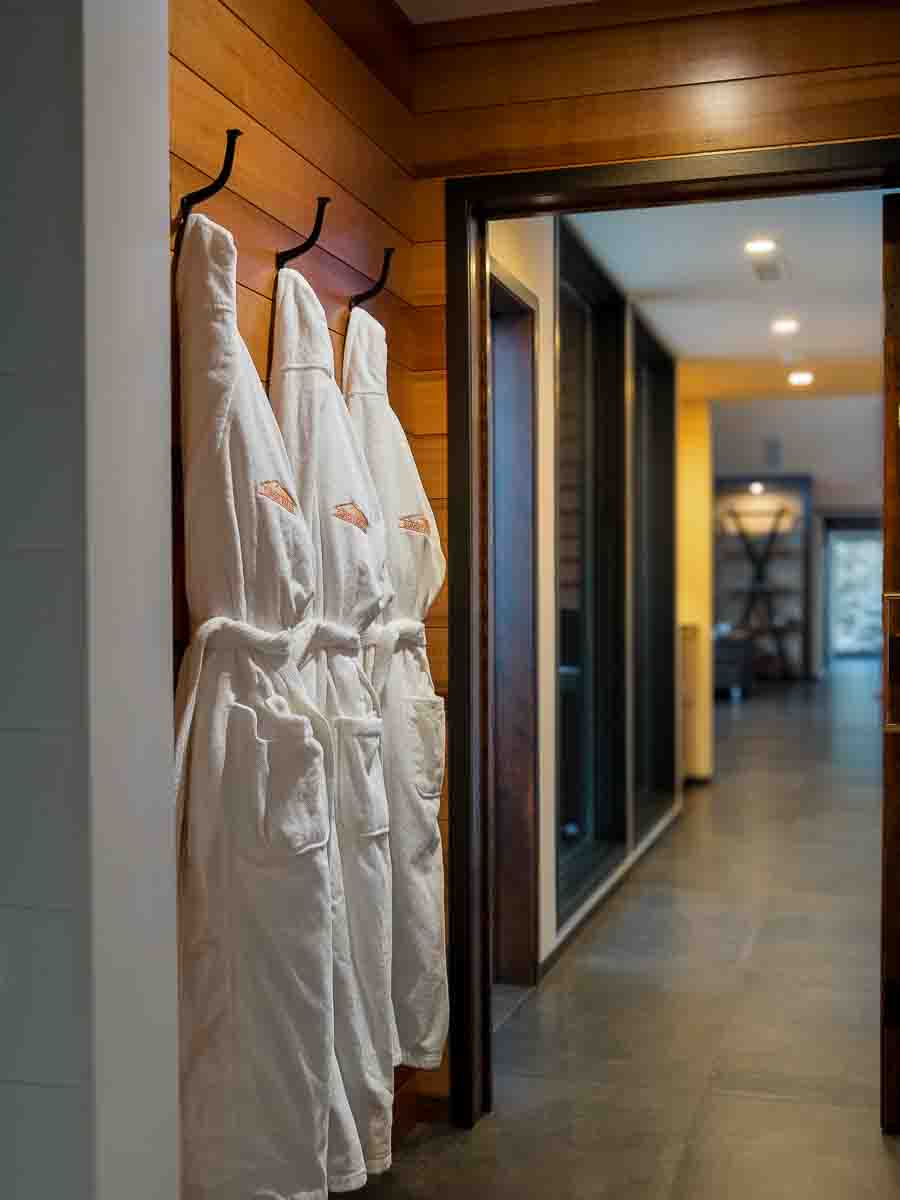 Turkish cotton robes hanging in the cedar-lined hall to the wellness suite &mdash; Sunset Falls Restore