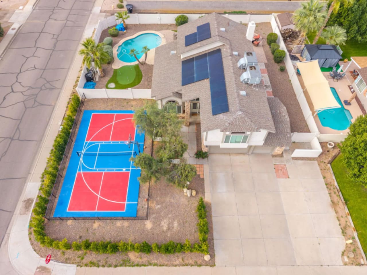 Aerial view of resort compound featuring sports court, multiple pools, solar power, and extensive outdoor entertaining spaces.