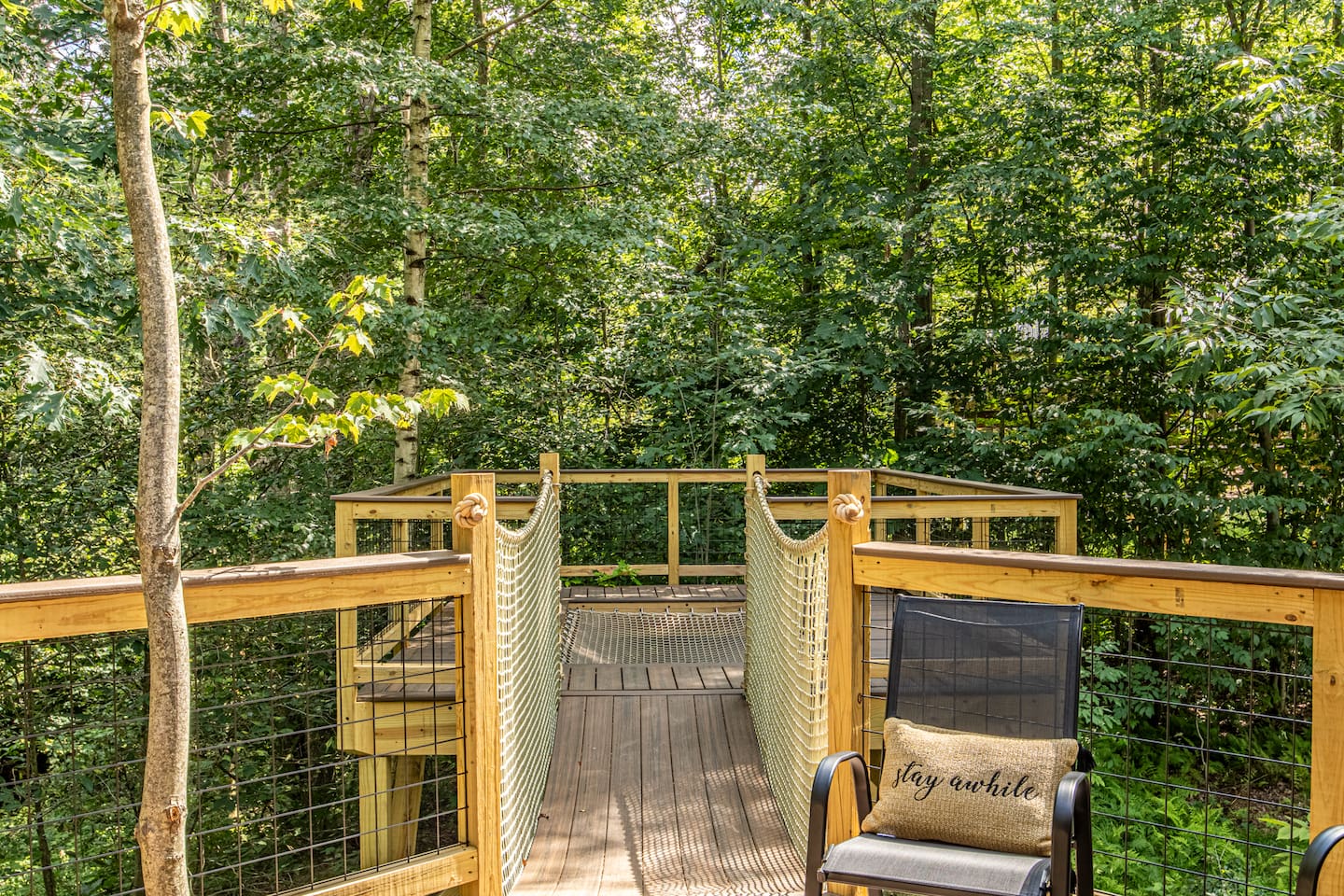 This unique treehouse deck offers a luxurious outdoor experience with an elevated hot tub and XL hammock seamlessly built into the deck floor. Additionally, enjoy the refreshing outdoor shower while surrounded by nature, making it a perfect retreat.