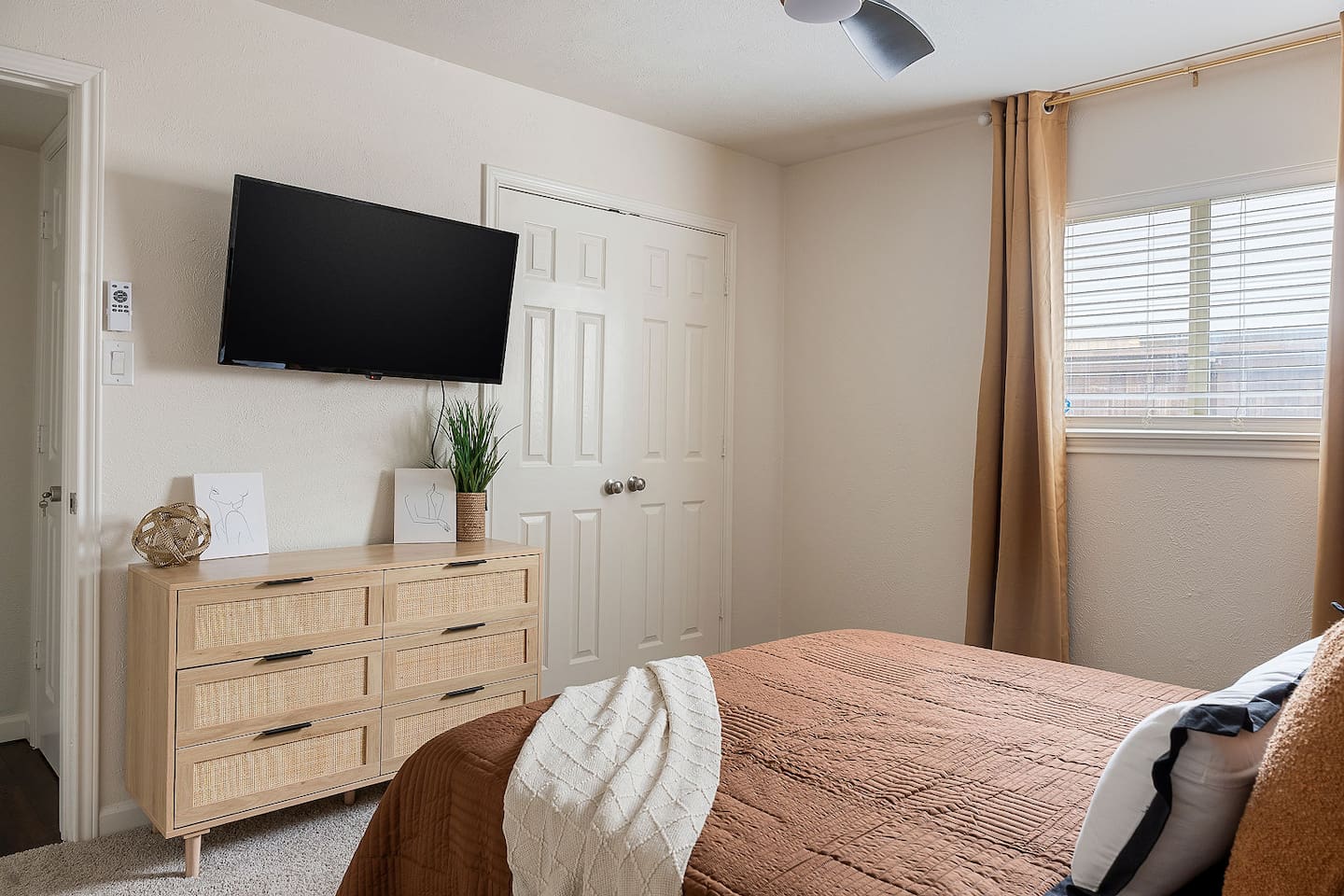 The bedroom is outfitted with a sleek dresser and a wall-mounted television, creating a modern and efficient area for leisure.