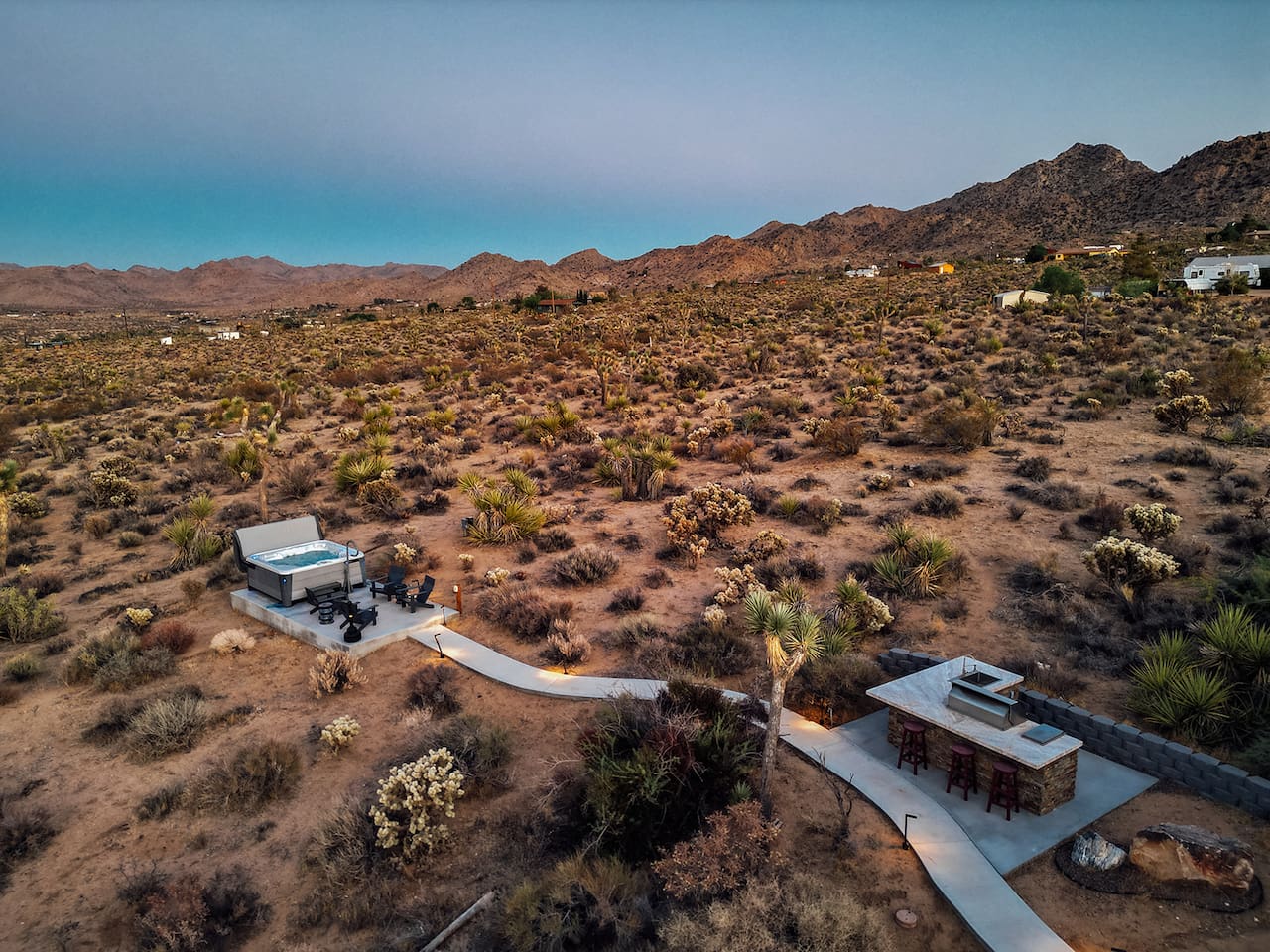 Enjoy sweeping desert and mountain views from your private backyard, complete with a hot tub, fire pit, and outdoor bar seating — the perfect spot for stargazing or sunset gatherings.