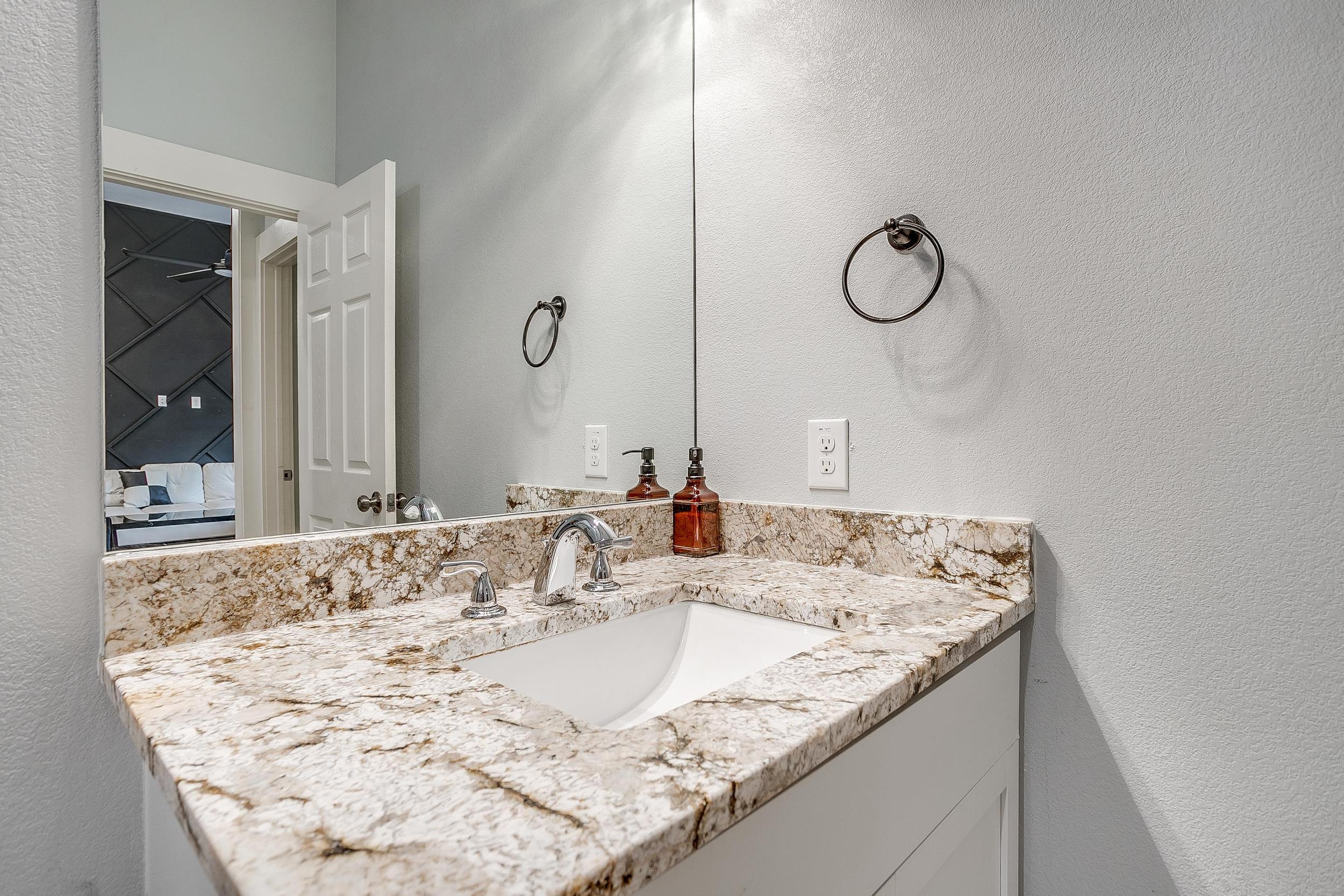 Granite vanity with fresh towels and simple modern setup.